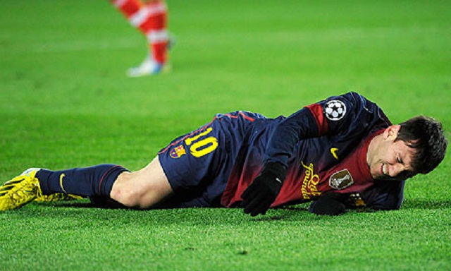 Barcelona's Lionel Messi hurts his knee late in the 0-0 draw with Benfica.