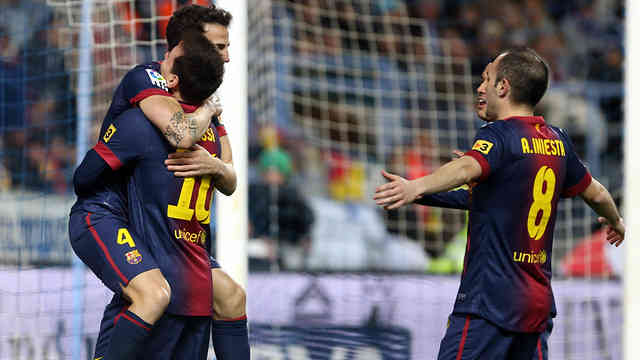 Cesc Fabregas celebrates his goal with Lionel Messi against Malaga