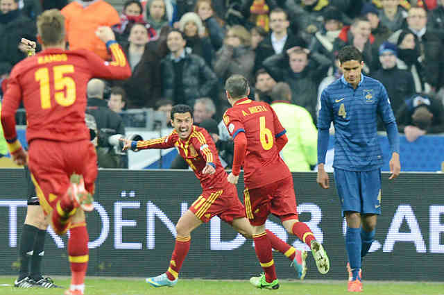 Sergio Busquets celebrates his goal while Raphael Varane upset with the lose