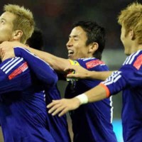 Honda celebrates his goal with team mates