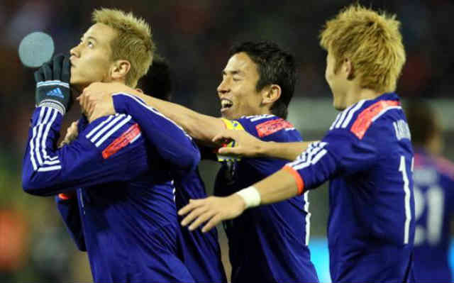 Honda celebrates his goal with team mates